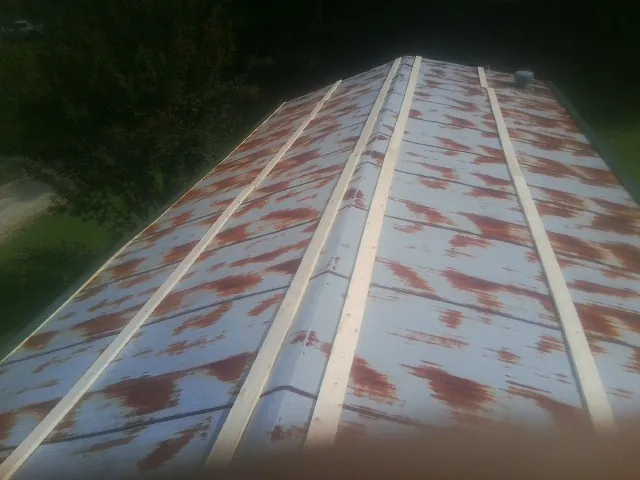 Rusted metal roof panels with new wood purlins before replacement — Storm Damage Roof Repair in Andalusia by Roofing Brothers